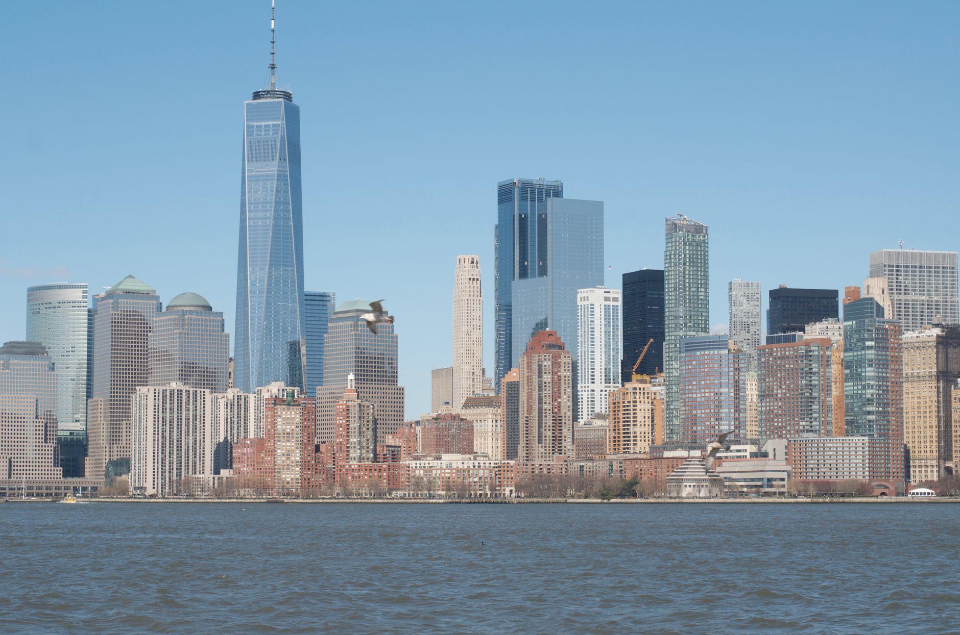 Panoramic view of New York City's iconic skyline under a clear blue sky.