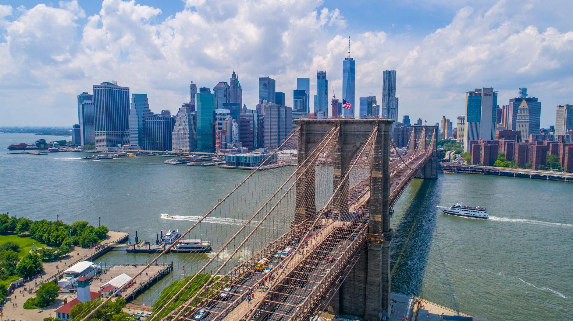 Breathtaking aerial view of the iconic Brooklyn Bridge and Manhattan skyline under a clear sky.