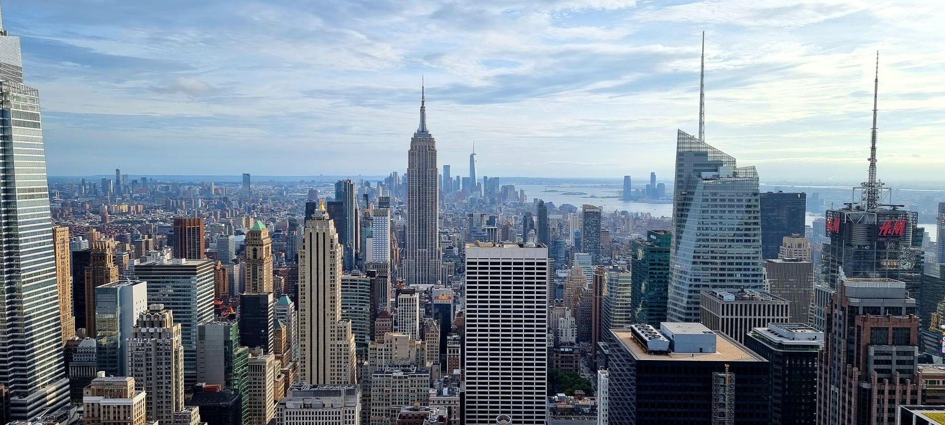 Aerial view of New York City skyline featuring iconic skyscrapers under a cloudy sky.