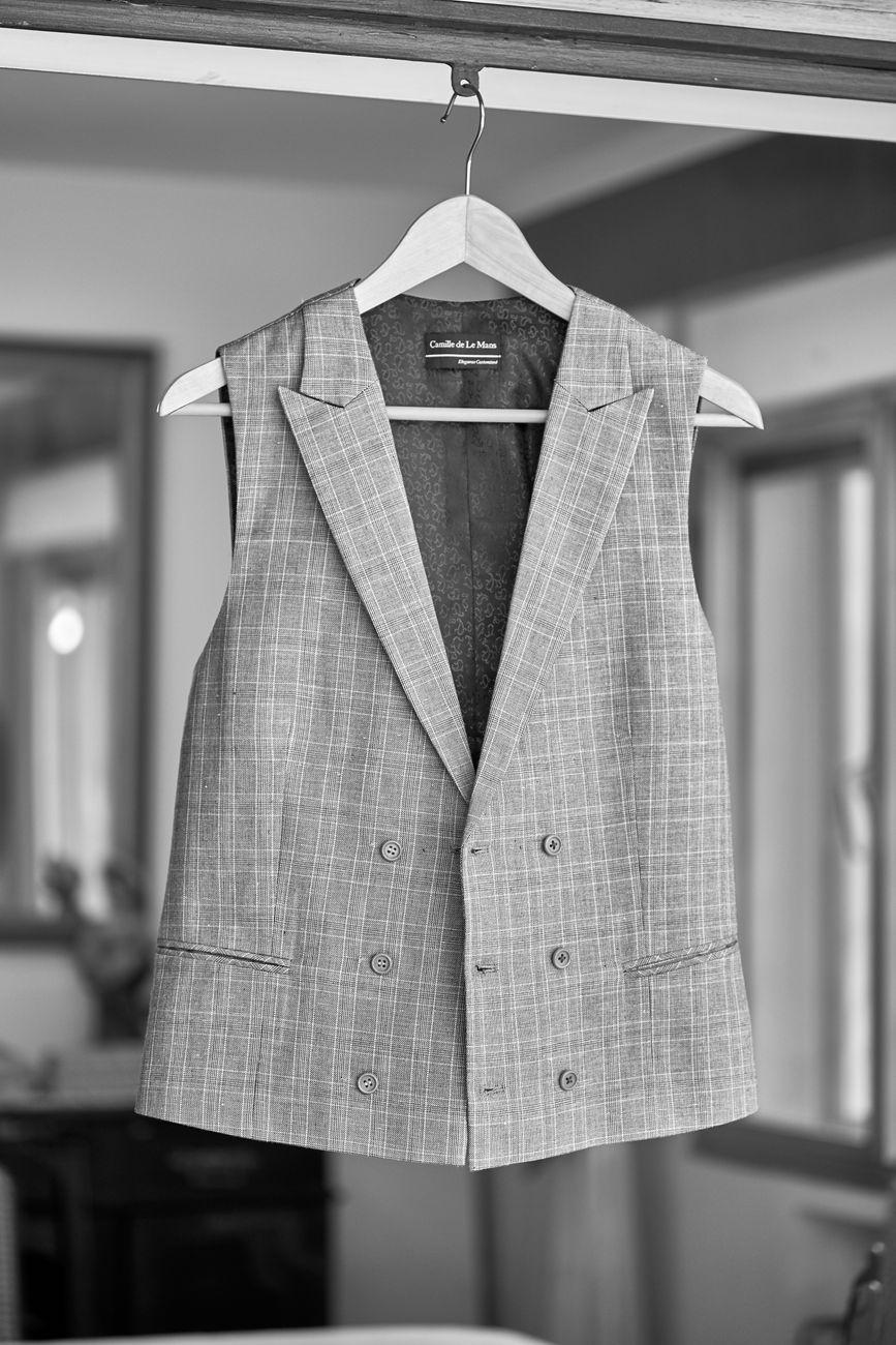 Stylish gray vest on a hanger in an indoor setting, perfect for a fashion statement.