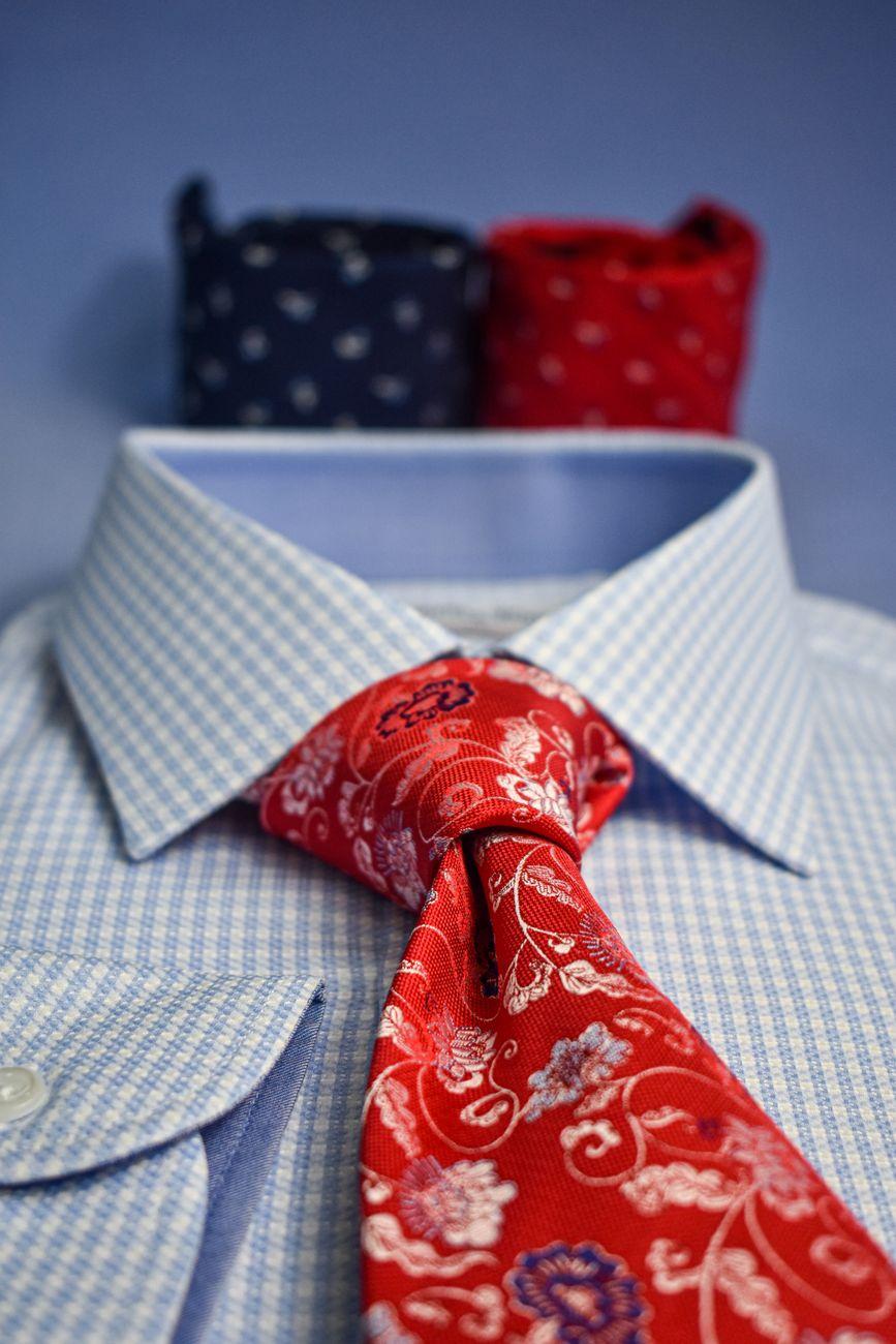 Detail shot of a checkered shirt with a red floral necktie perfect for formal occasions.